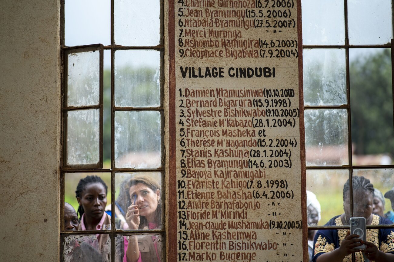 Esther Dingemans looks into a monument to the victims of a massacre that lists their names and a date.