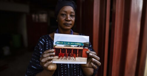 Woman holding picture of Guinea stadium